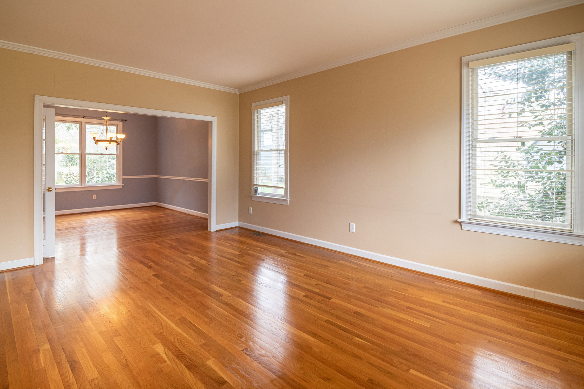 Empty living and dining room with refinished hardwood floors